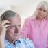 Elderly man putting his hand on his head having a hard time remembering