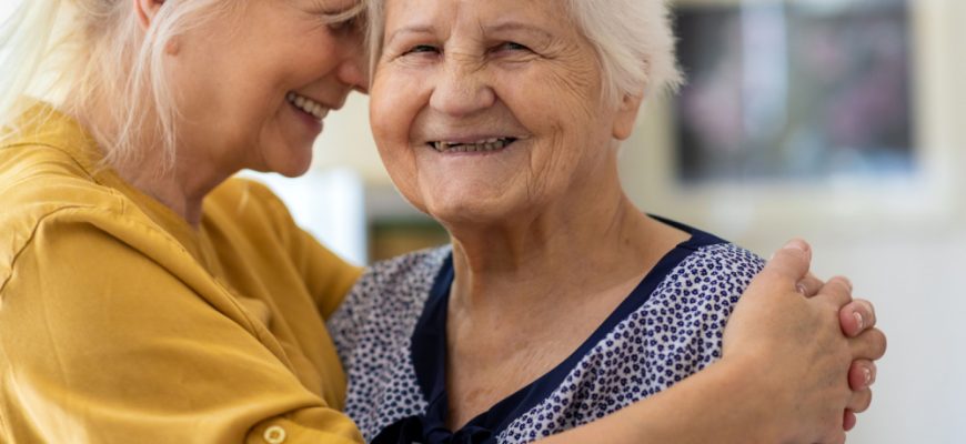 Lady hugging her elderly mother.